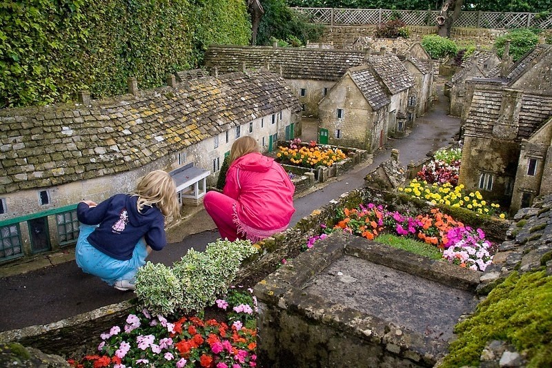 Ngôi làng Bourton-on-the-Water nằm ở Gloucestershire, Anh không chỉ nổi tiếng bởi con đường đẹp như tranh, hai bên đường phủ kín cây xanh cùng con sông Windrush xinh đẹp hiền hòa mà chủ yếu còn bởi  ngôi làng tí hon, mô hình thu nhỏ ngôi làng thật.